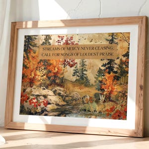 May include: A framed art print featuring a landscape scene with autumn foliage in shades of orange, red, and green. The print includes the text "STREAMS OF MERCY NEVER CEASING, CALL FOR SONGS OF LOUDEST PRAISE."