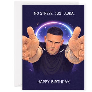 May include: Greeting card with a cartoon illustration of a man with outstretched arms. The card has the text "NO STRESS. JUST AURA." above the man's head and "HAPPY BIRTHDAY." below. The background is a dark blue with a glowing purple and white aura.