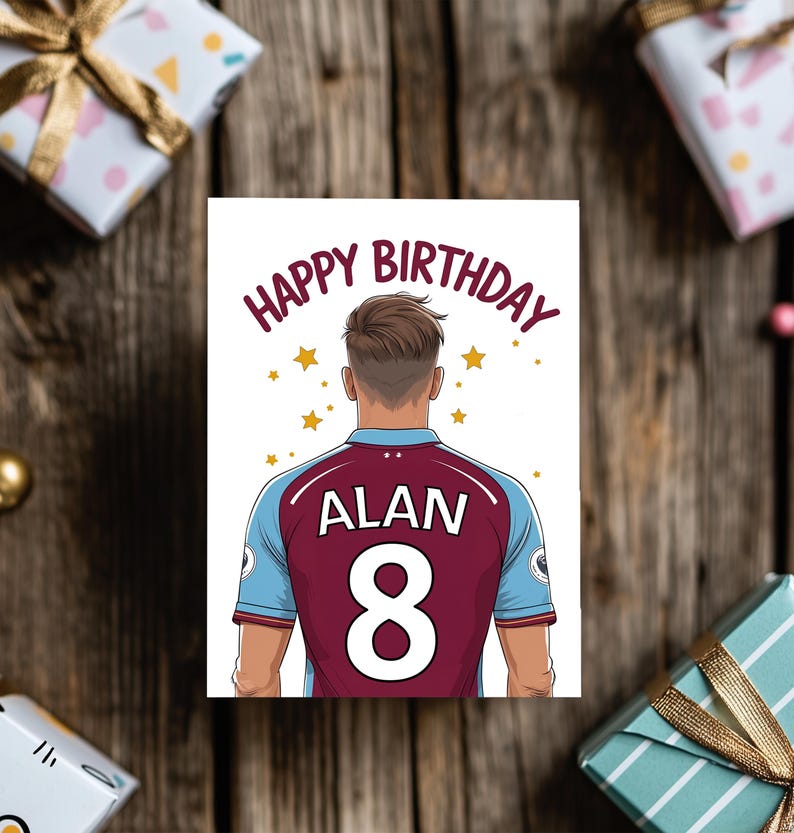 May include: A birthday card featuring a cartoon illustration of a soccer player wearing a maroon and blue jersey with the name "ALAN" and the number "8" on the back. The card has the text "HAPPY BIRTHDAY" in a circle around the player's head.