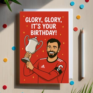 Tarjeta de cumpleaños del Manchester United con Bruno Fernandes sosteniendo un trofeo. Tarjeta de felicitación de fútbol para fans de los Red Devils. Tema: Glory Glory.