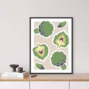 Könnte beinhalten: Gerahmter Druck mit stilisierten grünen Artischocken mit lila Akzenten und angeschnittenen Abschnitten. Das Kunstwerk ist vor einem beigen Hintergrund platziert und schafft ein modernes, botanisches Thema.