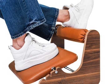 May include: A wooden footrest with a brown leather seat and a brown leather footrest. The footrest is designed to be used while sitting in a chair. The footrest is made of wood and has a natural finish.