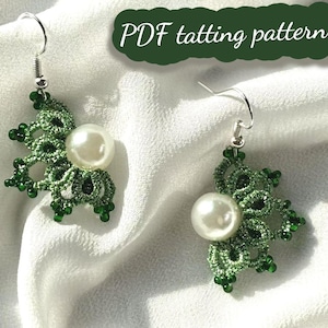 以下が含まれることがあります： 大きな白い真珠を中央に配した、手作りの緑色のタティングレースのイヤリングのペア。イヤリングは、小さな緑色のビーズと銀色のイヤーフックを備えたフローラルデザインです。「PDF tatting pattern」というテキストが表示されています。