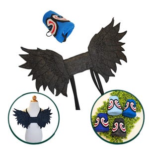 May include: A set of dark gray felt wings with jagged edges and black straps, accompanied by blue and gray cylindrical cuffs featuring a white, red, and black swirl design. The wings are shown on a mannequin and the cuffs are displayed separately.