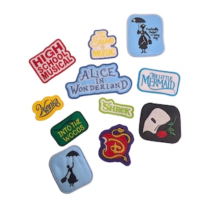 Puede incluir: Un conjunto de parches bordados coloridos con texto e imágenes de musicales y películas populares. Los títulos incluyen "High School Musical", "Alicia en el País de las Maravillas", "La Sirenita" y "Shrek".