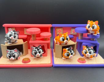 May include: Two miniature cat playhouses, one red and one purple, each with several cartoon cat figurines. The cats are in various poses, some in boxes, others on platforms. Each playhouse has a food bowl.