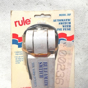 May include: A Rule-A-Matic automatic switch with inline fuse, model 35F, on a cardboard backing. The switch is white and silver, with the brand name and product details printed on the packaging. Made in the U.S.A.