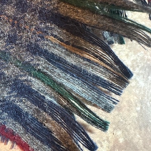 May include: A white ceramic mug with a black handle and the text "But First, Coffee" in a black, handwritten-style font. The mug is on a white surface.