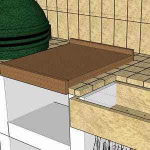 May include: A green ceramic grill with a black band and a brown wooden countertop. A stainless steel faucet is on the right. The countertop is brown and has a raised edge.