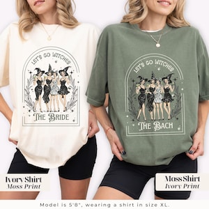 May include: Two oversized t-shirts, one ivory and one moss green, each featuring a graphic of stylized witches. The ivory shirt says "The Bride," and the moss green shirt says "The Bach." Both shirts have the text "Let's Go Witches."