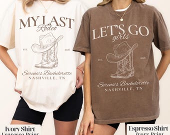 May include: Two t-shirts, one ivory and one espresso, each with a graphic of a cowboy hat and boots. The ivory shirt reads "MY LAST Rodeo" and the espresso shirt says "LET'S GO girls". Both shirts include "Serena's Bachelorette, Nashville, TN".