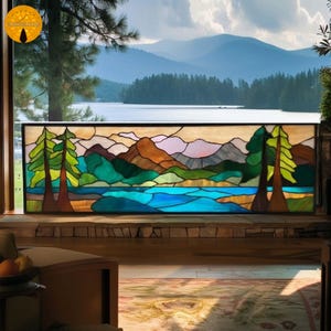 May include: A stained glass window showing a landscape with mountains, a lake, and trees. The artwork uses a vibrant palette of blues, greens, browns, and oranges, framed in black. The window is set against a backdrop of a lake and mountains in the distance.