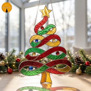 May include: A stained glass Christmas tree ornament featuring swirling red, green, and yellow textured glass ribbons. The tree is topped with a yellow star and accented with small, round, colored glass beads. It hangs from a silver metal chain.
