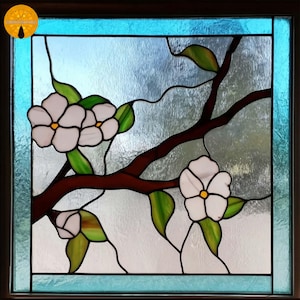 May include: Stained glass window featuring white blossoms with yellow centers, green leaves, and brown branches. The window has a blue border and a textured background, creating a nature-inspired design.