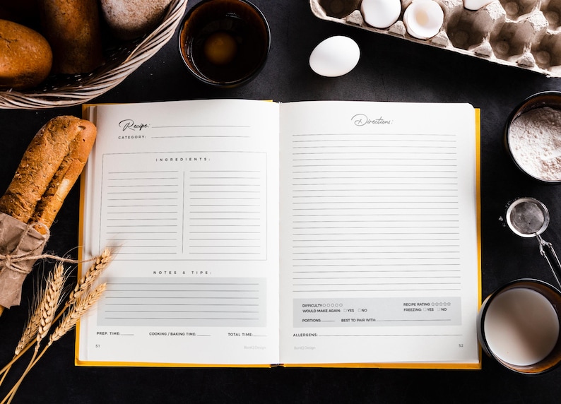 May include: An open recipe book with yellow edges, surrounded by baking ingredients. A loaf of bread, eggs, flour, and milk are arranged around the book. The book has sections for ingredients, directions, and notes.
