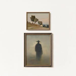 May include: Two framed landscape paintings. The top painting depicts a road with trees and a soft, pastel sky. The bottom painting features a silhouetted figure in a hat, set against a hazy, muted background. Both paintings have gold frames.