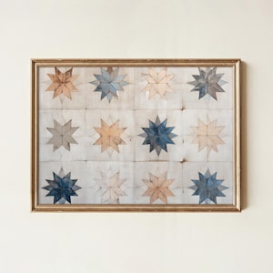 May include: A framed artwork featuring a grid of twelve star-shaped designs. The stars are in shades of blue, tan, and cream, set against a light background. The frame is a warm gold color, adding a touch of elegance to the piece.