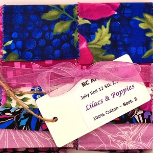 Könnte beinhalten: Ein Stoff-Jelly-Roll-Bundle mit Quadraten aus floralem und gemustertem Baumwollstoff in Blau-, Rosa- und Lilatönen. Das Bundle ist mit einem rosa Band und einem Etikett mit der Aufschrift "Lilacs & Poppies" gebunden.