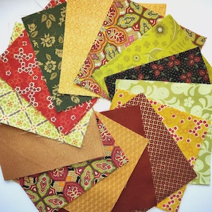 Könnte beinhalten: Eine Ansammlung farbenfroher Stoffquadrate, kreisförmig angeordnet. Die Quadrate weisen verschiedene Muster auf, darunter Blumen-, geometrische und Paisley-Designs, in Rot-, Grün-, Gelb- und Brauntönen. Ideal für Quilt- oder Bastelprojekte.