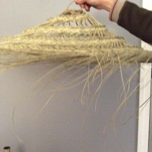 Puede incluir: Un gran sombrero de paja tejido con un ala ancha y un color beige natural.