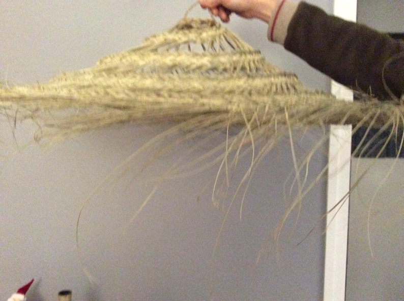 Puede incluir: Un gran sombrero de paja tejido con un ala ancha y un color beige natural.