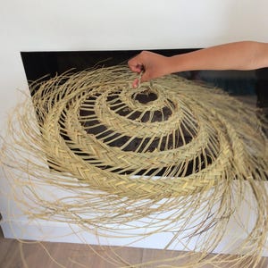 Puede incluir: Un sombrero grande, redondo, tejido de paja natural con una larga franja que fluye. El sombrero es de color marr&oacute;n claro y tiene un patr&oacute;n en espiral en el centro.