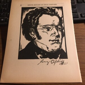 May include: A black and white woodcut illustration of Franz Schubert, a famous composer, with the text "MINUTE SKETCHES OF GREAT COMPOSERS" and the number "40" above the image. The image is on a cream-colored page.