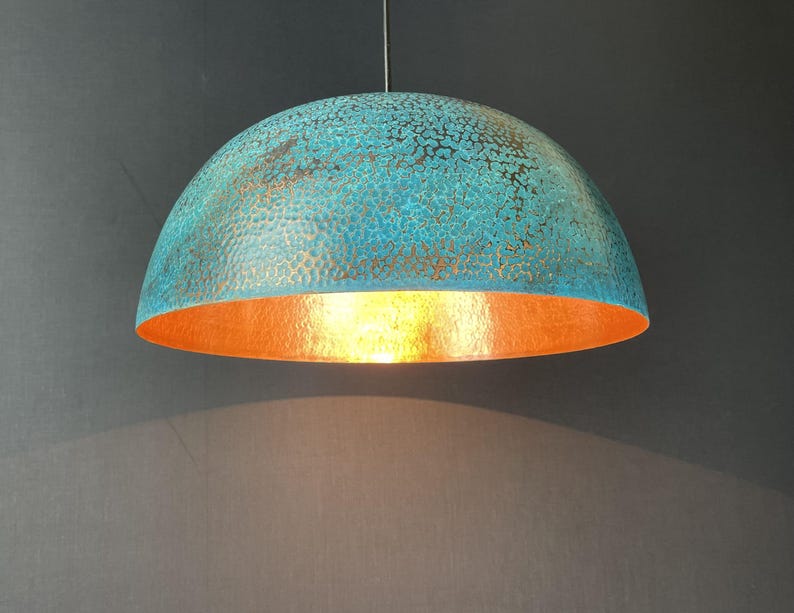 May include: A turquoise and copper dome-shaped pendant light fixture with a hammered texture.