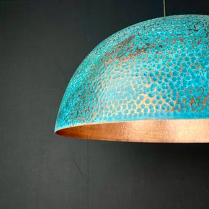 May include: A turquoise and copper dome-shaped pendant light fixture with a hammered texture.