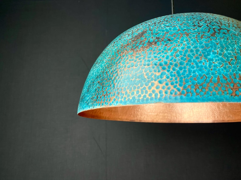 May include: A turquoise and copper dome-shaped pendant light fixture with a hammered texture.