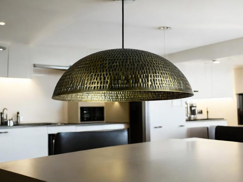 copper dome light fixture with detailed perforations hanging in modern dining area, showcasing the warm copper interior glow