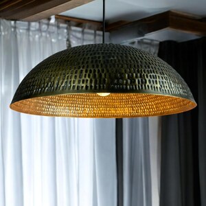 copper pendant lamp in minimalist setting, highlighting the contrast between exterior patina and golden interior