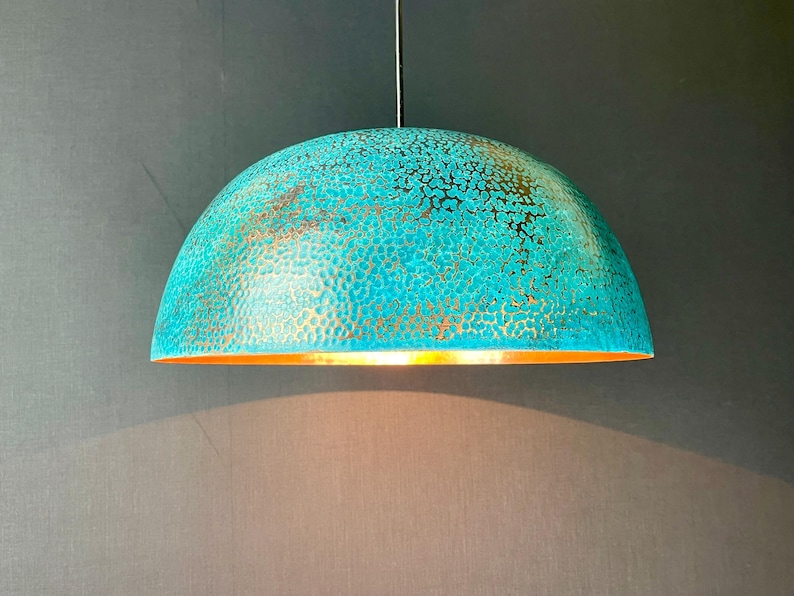 May include: A turquoise and gold pendant light with a hammered metal finish. The light is round and has a dome shape.