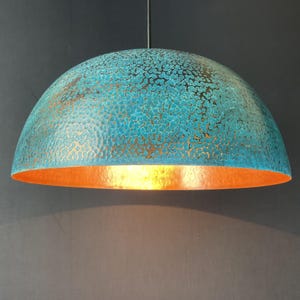 May include: A teal blue and copper dome-shaped pendant light fixture with a hammered metal finish.