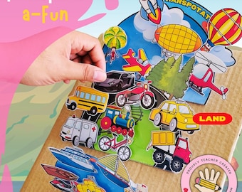 May include: A cardboard box with a colourful illustration of different modes of transport. The box is divided into three sections: "Air", "Land", and "Sea". Each section features various vehicles, including aeroplanes, cars, boats, and trains. The text "Transport a-Fun" is written in pink at the top of the box.