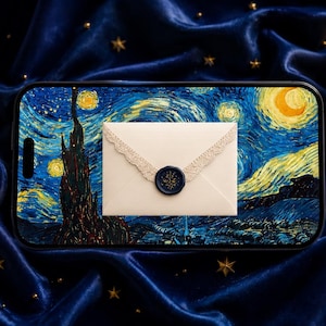 Peut inclure: Une coque de téléphone avec la peinture "La Nuit étoilée" de Van Gogh, avec une enveloppe blanche ornée de dentelle et d'un sceau de cire bleu marine. La scène se déroule sur un tissu de velours bleu foncé avec des accents dorés.