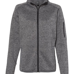 May include: A grey and black fleece zip-up jacket with a stand-up collar and a zipped pocket on the left sleeve.
