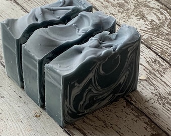 May include: Three bars of handmade soap with a marbled gray and white design. The soap is stacked on top of each other.