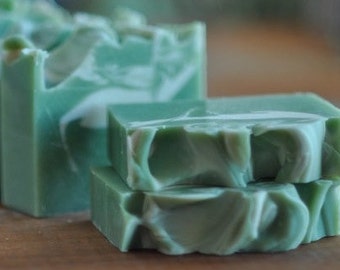 May include: Three bars of handmade soap with a green and white swirl pattern. The soap is made with natural ingredients and is perfect for sensitive skin.
