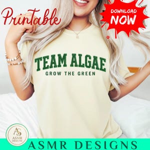 Peut inclure: Un t-shirt à manches courtes jaune pâle avec le texte vert foncé TEAM ALGAE dans une police universitaire, accompagné du texte plus petit GROW THE GREEN en dessous. Le t-shirt présente un col rond et une coupe décontractée.