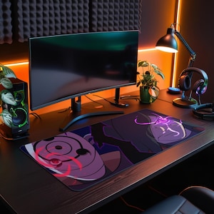 May include: A black and purple gaming mouse pad with a stylized illustration of a character from the anime series Naruto. The character has a purple mask with a red spiral design and a purple and black cloak.