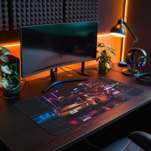 May include: A black computer desk with a curved monitor, a black speaker, a desk lamp, a pair of headphones, and a mouse pad with a city scene and a car in the foreground.