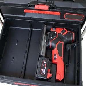 May include: A black plastic tool storage drawer containing a red and black cordless jigsaw with a 5.0 Ah M18 Redlithium battery attached. The tool features a speed dial labelled 1 through 5 and the word FUEL printed on the side of the housing.