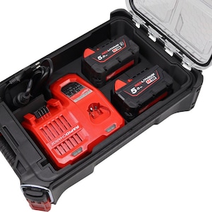 Può includere: Una valigetta per utensili nera e rossa con coperchio trasparente, contenente un caricabatterie rapido rosso, due batterie 5.0 M18 REDLITHIUM nere e rosse e un cavo di alimentazione. La valigetta è aperta, rivelando il contenuto.