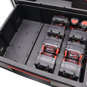 Può includere: Una cassetta degli attrezzi nera con un cassetto aperto, che rivela sei batterie nere e rosse all'interno. Le batterie sono disposte in due file da tre.