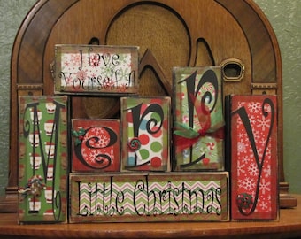 May include: Wooden blocks spelling out "Have Yourself a Merry Little Christmas" with a variety of festive patterns and colors. The blocks are arranged in a staggered pattern.