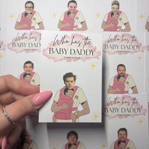 May include: Cards with illustrations of men holding babies in pink carriers. The cards have the text "Who has the BABY DADDY" with "Scratch to reveal" underneath. The cards feature different celebrities.
