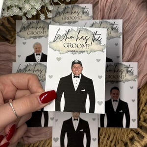 May include: A rectangular white card featuring the text Who has the GROOM? and Scratch to reveal. The card displays a graphic of a person wearing a black tuxedo with a white shirt and a black bow tie, surrounded by small grey heart icons.