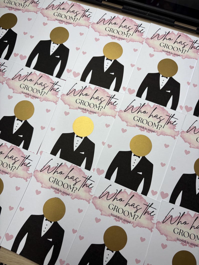 May include: A collection of rectangular game cards featuring the text Who has the GROOM? Scratch to reveal. Each card displays a black tuxedo illustration with a circular gold scratch-off sticker for the head, accented by pink watercolour and hearts.