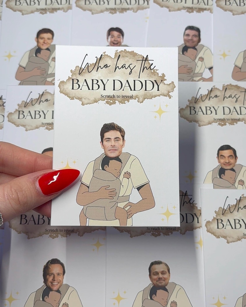 May include: A scratch-off card with the text "Who has the BABY DADDY" in a brown cloud design. The card features a cartoon image of a man holding a baby in a carrier. Other cards with different images are in the background.